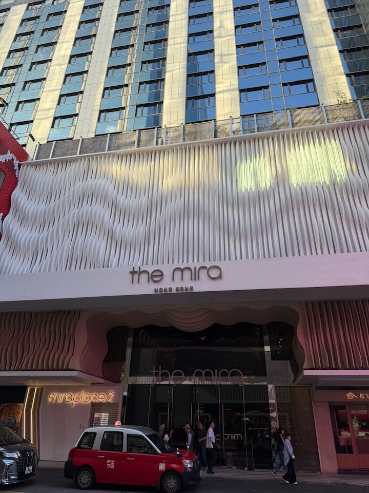 The hotel entrance featuring a wavy, light pink exterior.