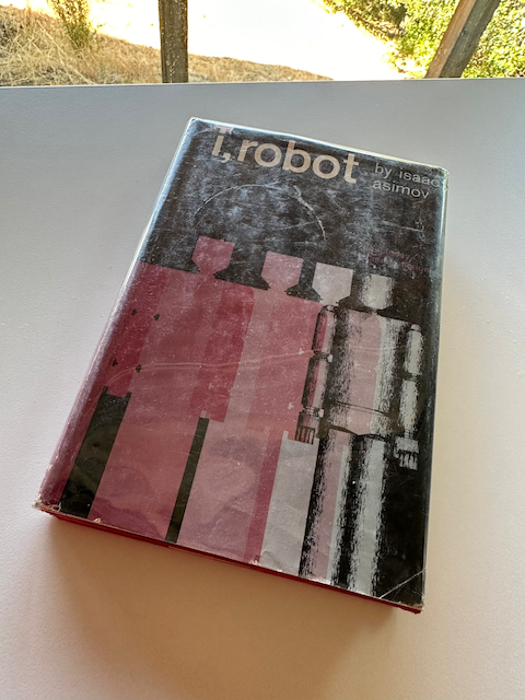 Photo of the book "I, Robot" with four boxy robots on the cover.