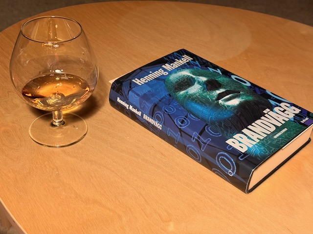 The Mankell novel "Firewall" on my side table together with a glass of cognac.