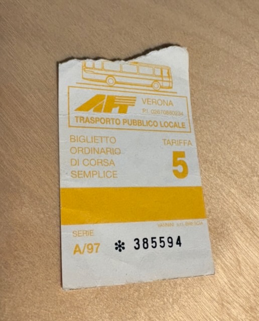 A paper bus ticket with yellow printing. It's torn at the top.