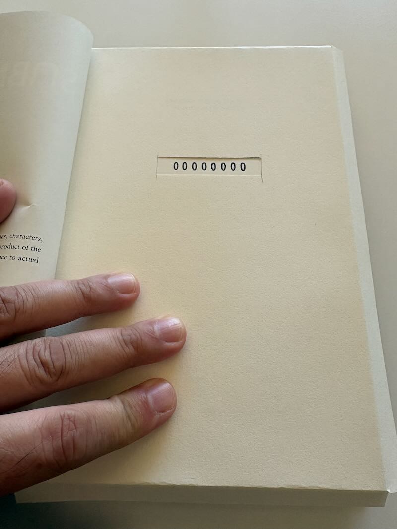 00000000 stamped to a book through the cut-out window.